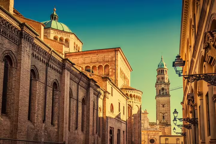 Historic brick facades and cathedral bell tower in Parma’s old town, seen on a guided private walking tour of the city
