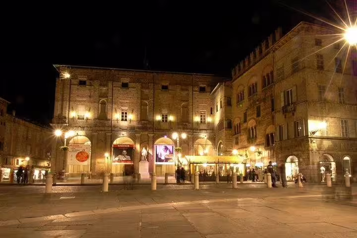Night view of Parma’s illuminated historic square and palaces experienced on a private guided walking tour in Italy
