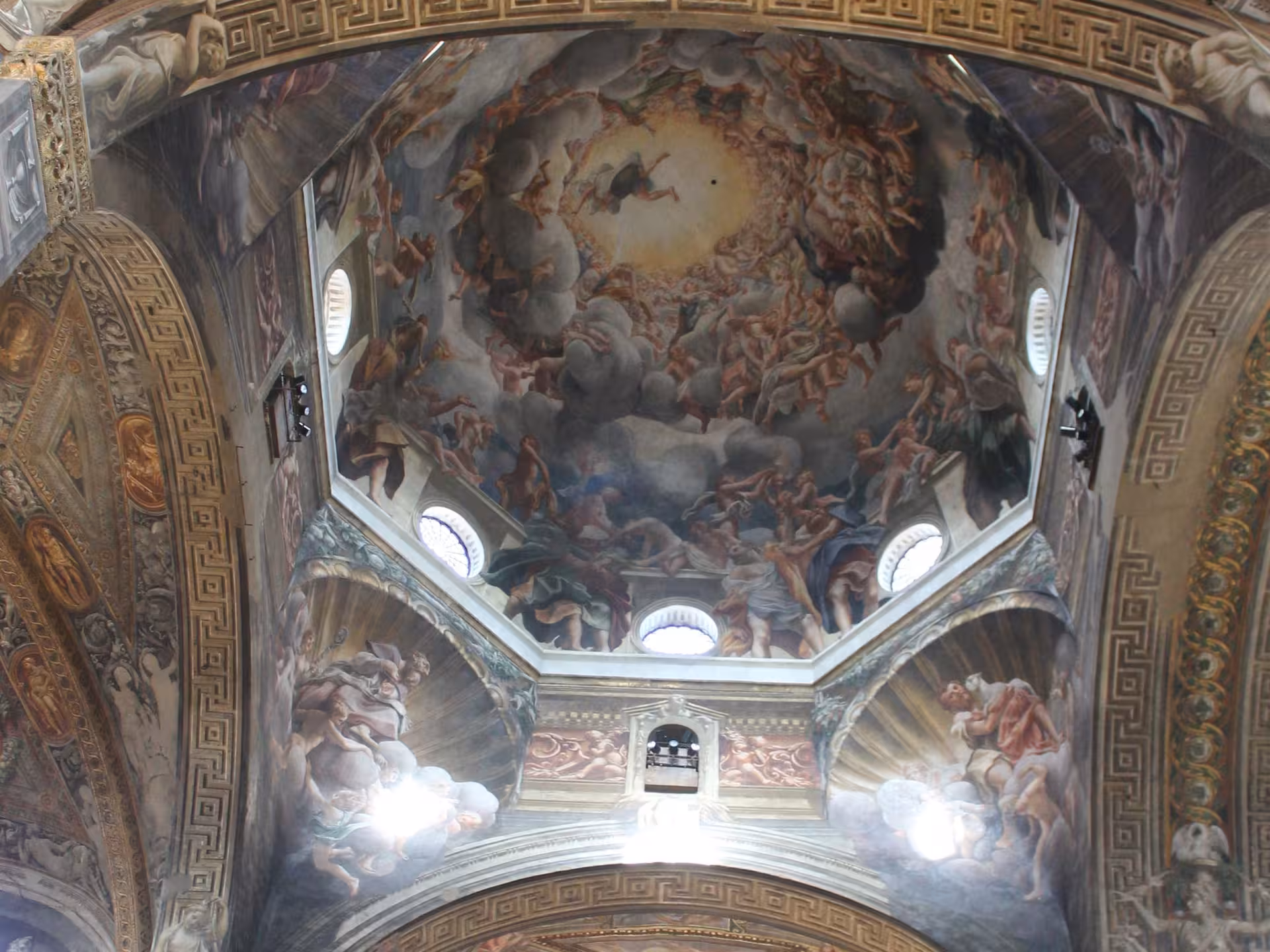 Intricate frescoed dome ceiling in Parma, showcasing stunning Renaissance art and architecture.