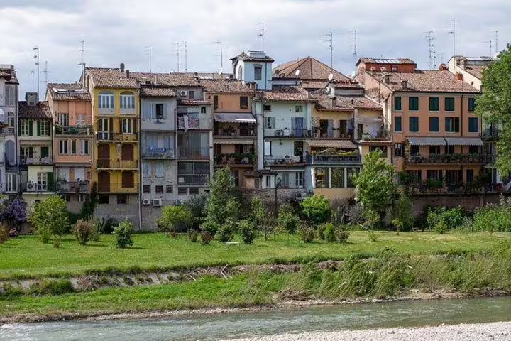 Colorful riverside houses along the Parma stream seen on a private walking tour with a local guide in Emilia-Romagna