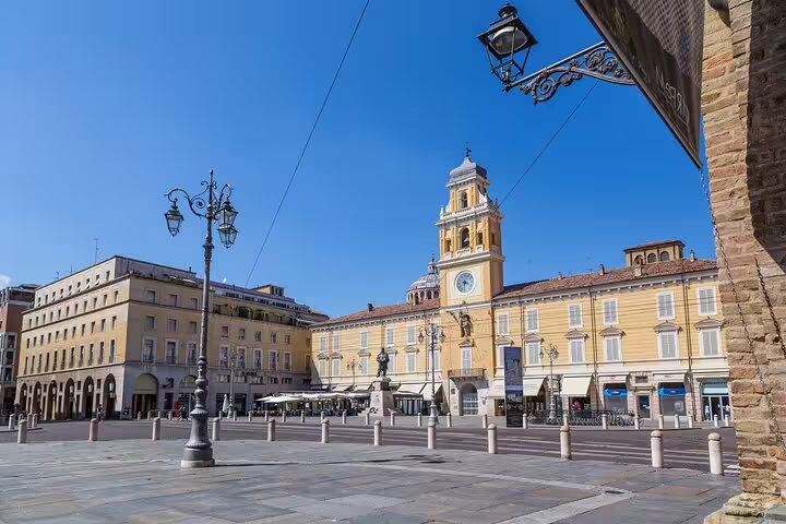 Piazza Garibaldi with Palazzo del Governatore clock tower on a sunny day during a private Parma walking tour with guide