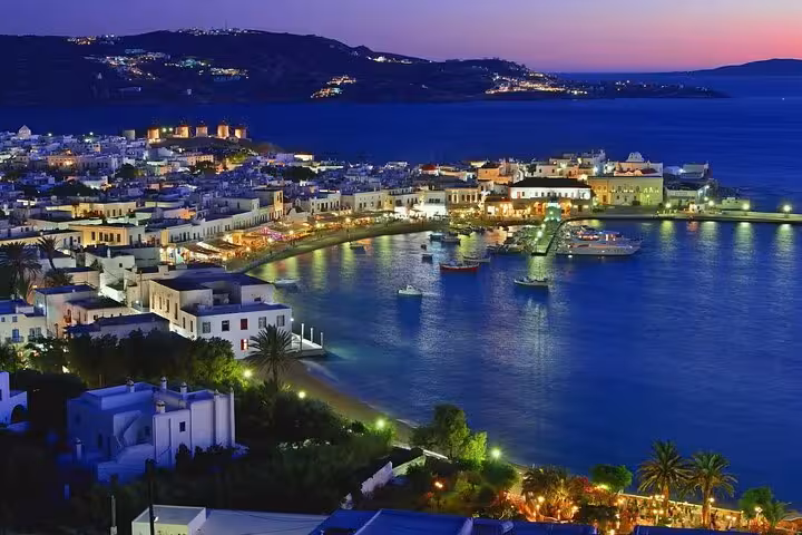 Paros Naoussa harbor at sunset with boats and waterfront lights, island-hopping on 7-day private tour from Athens