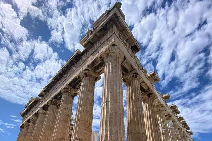 Low-angle view of the Parthenon columns under dramatic sky, featured on Athens half-day private car tour
