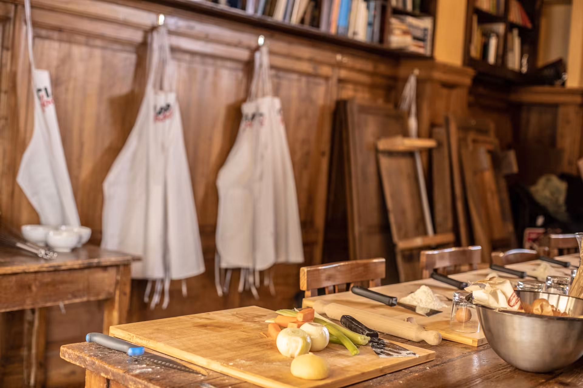 Rustic kitchen setup with aprons and fresh ingredients for a pasta cooking class in Florence.
