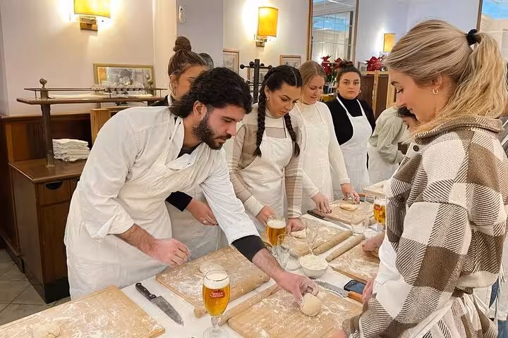 Participants learning to make pasta in a hands-on cooking class at Piazza Navona in Rome.