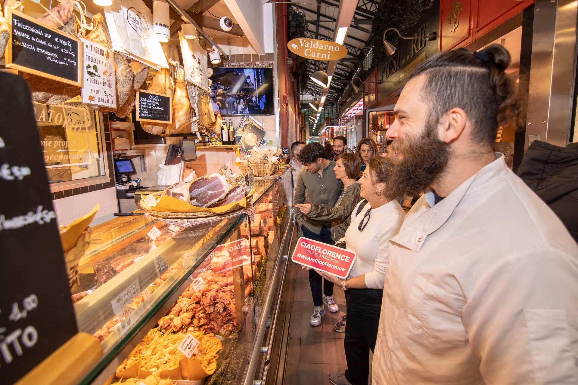 Cooking class participants enjoy a guided tour through Sant’Ambrogio Market, examining fresh local ingredients.
