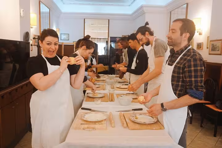 Enthusiastic participants enjoy hands-on pasta making in a lively Rome cooking class, learning traditional Italian recipes.