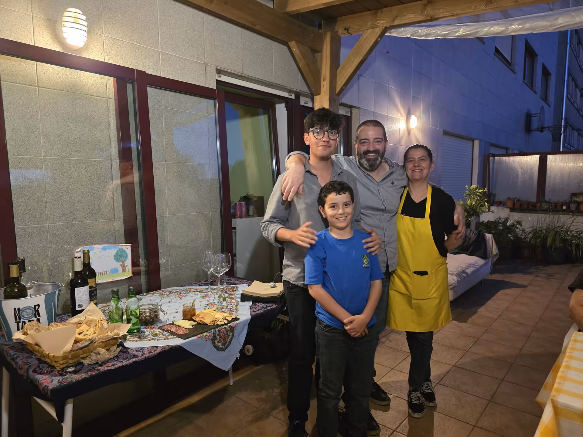 Family posing happily during an evening gathering at a pastel de nata cooking class terrace.