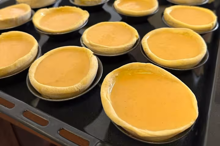 Freshly baked Pastel de Nata cooling on a tray, ready for a delightful terrace tour experience.