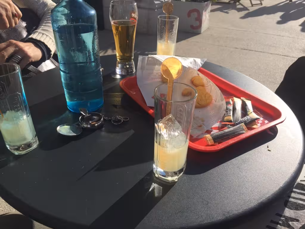 Pastis aperitif and local snacks on a café table, Marseille food tour tasting with traditional Provençal flavors