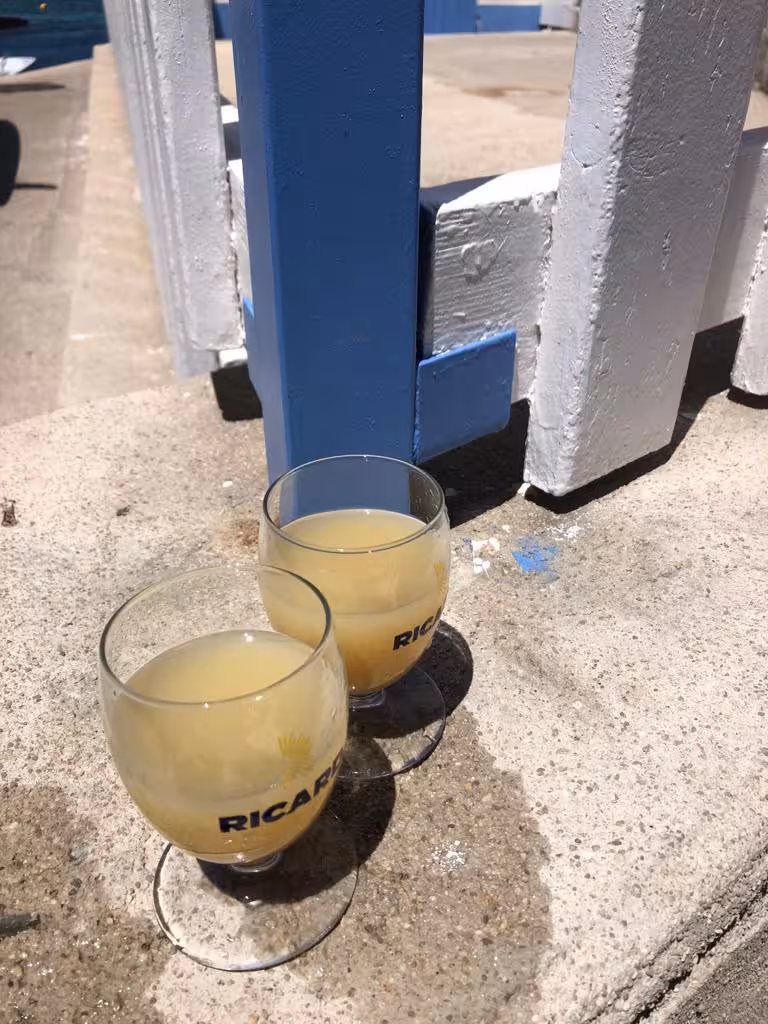 Two glasses of pastis aperitif on a Marseille Le Panier food tour, street-side drink stop in the sun