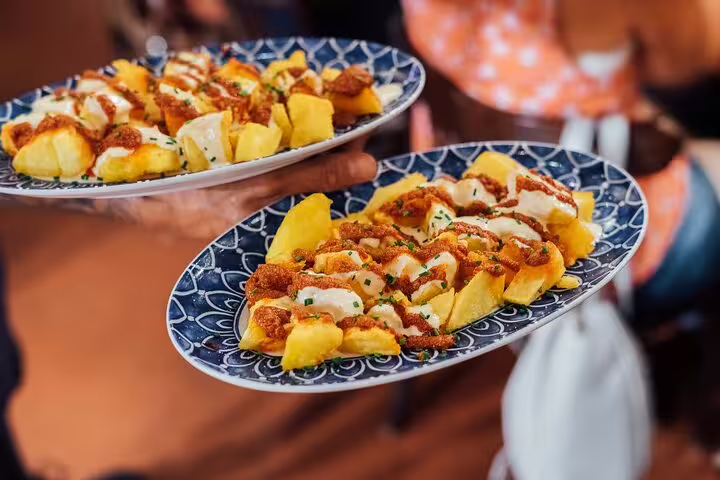 Plates of patatas bravas with aioli served on a private tapas and wine walking tour in Spain.