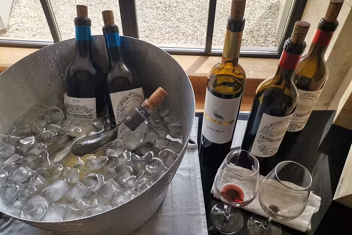 Chilled wine bottles in ice bucket with tasting glasses, featured in Pce's Vineyard sommelier course experience