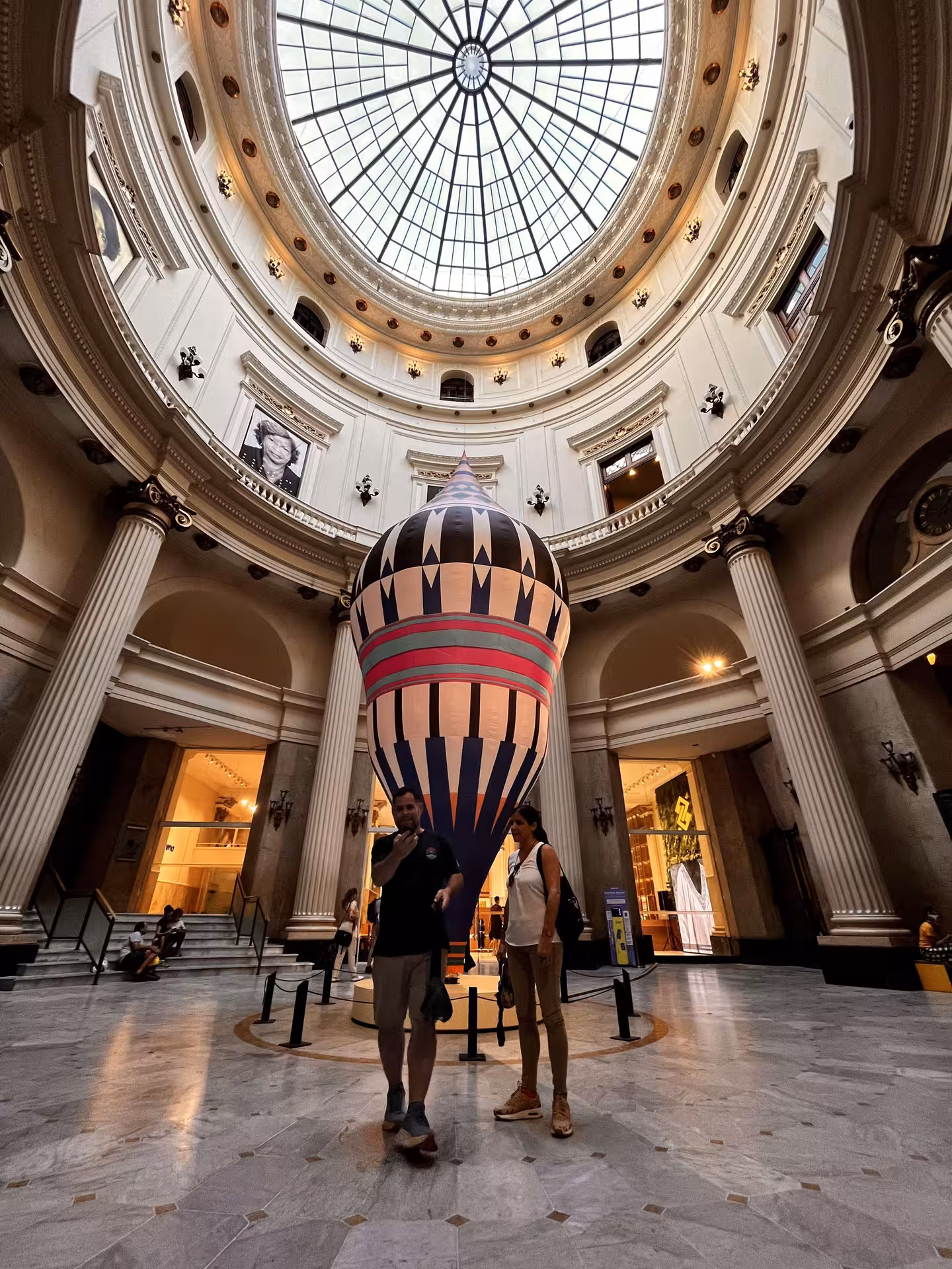 Pedicab tour stop inside Rio’s CCBB Cultural Center, under glass dome with hot air balloon art installation
