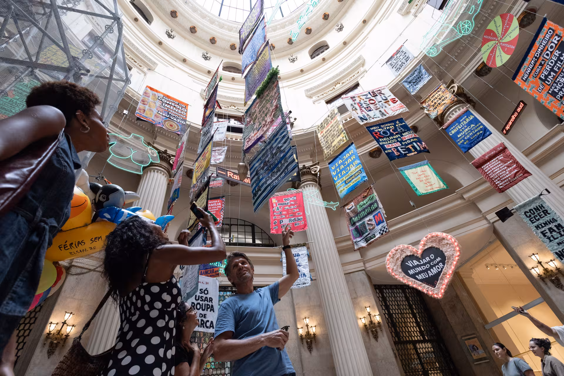 Visitors admire colorful art banners in Rio de Janeiro city centre on a pedicab tour cultural stop