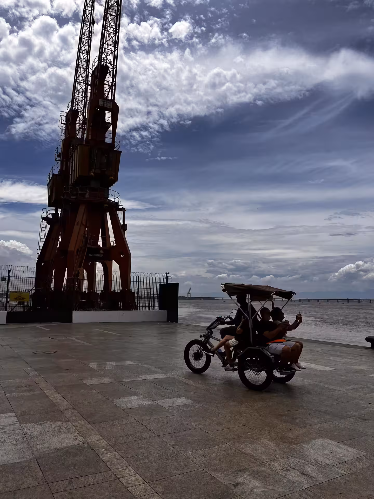 Pedicab tour along Rio de Janeiro port waterfront by historic dock crane in the city centre