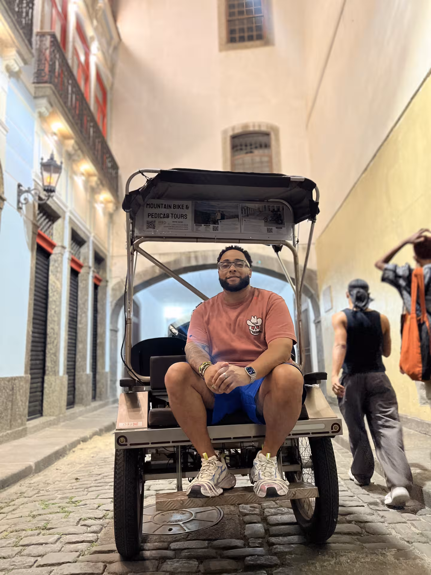 Pedicab driver on a cobblestone street in Rio’s historic city centre, showcasing the guided pedicab tour