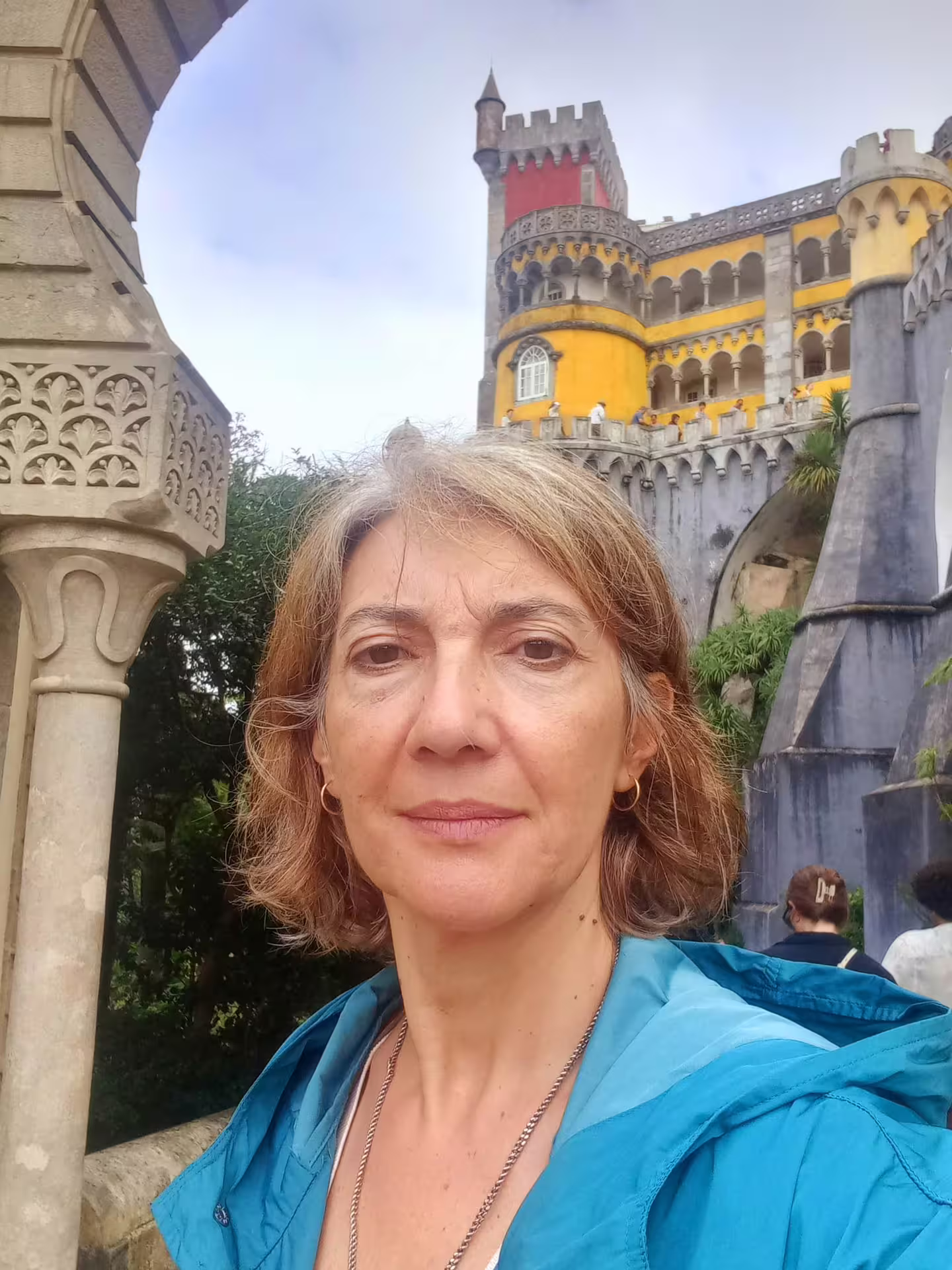Visitor exploring the vibrant Pena Palace on the Belem Coast Road to Sintra tour from Lisbon.