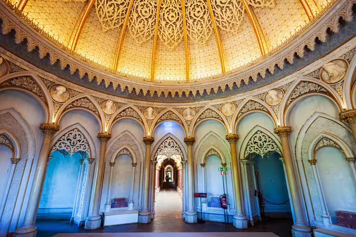 Intricate Gothic architecture inside Pena Palace in Sintra, showcasing ornate arches and a stunning golden dome ceiling on a full-day tour.