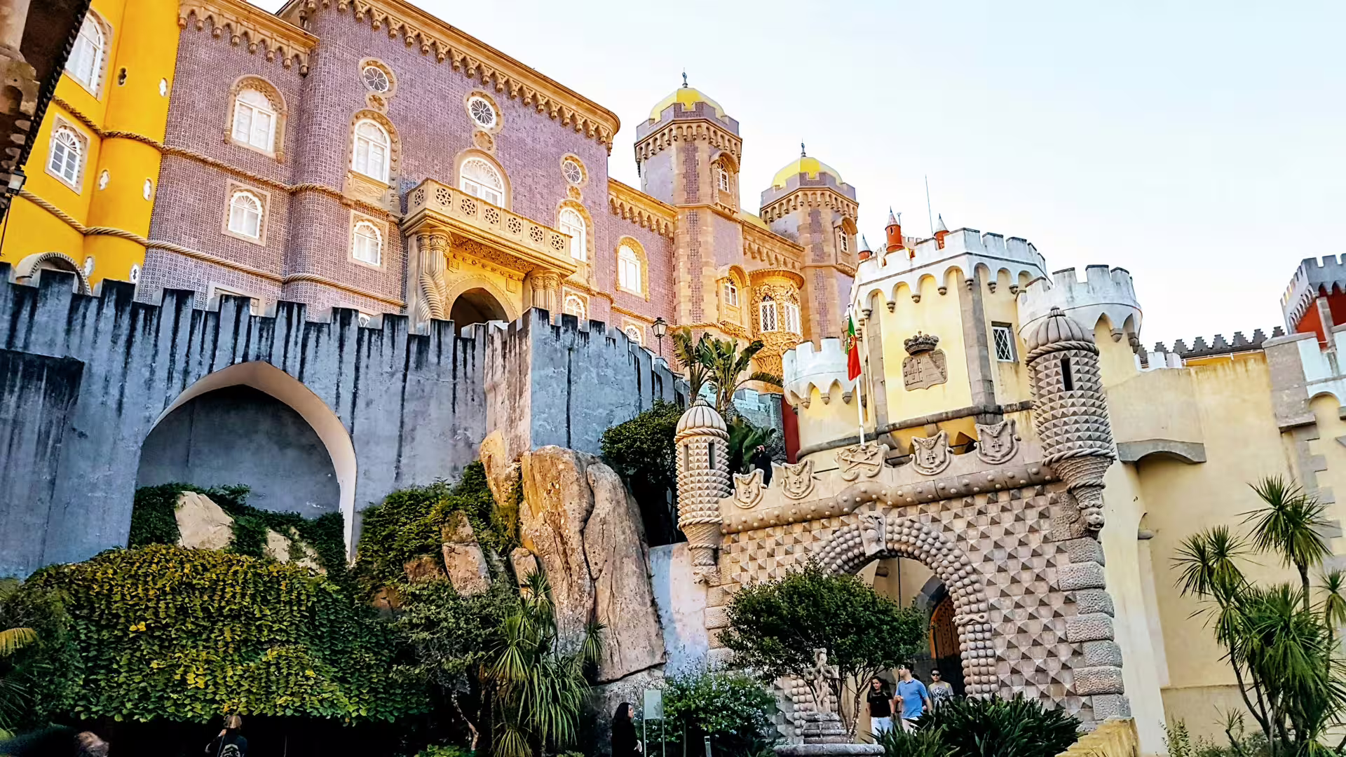 Colorful facade of Pena Palace in Sintra, showcasing striking architecture amidst lush greenery, featured on Lisbon tour.
