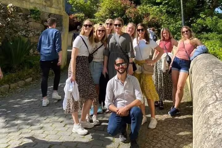 Group of tourists enjoying a sunny day at Pena Palace during a Sintra, Cabo da Roca, Cascais day trip from Lisbon.