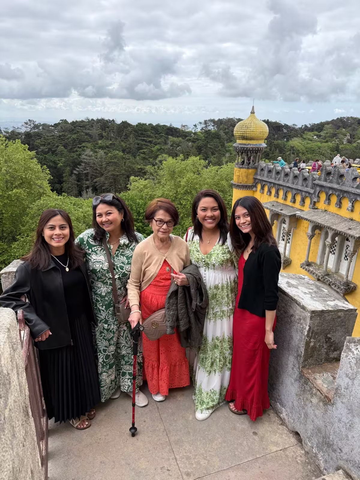 Group posing by the colorful turrets of Pena Palace, surrounded by lush Sintra forest scenery.