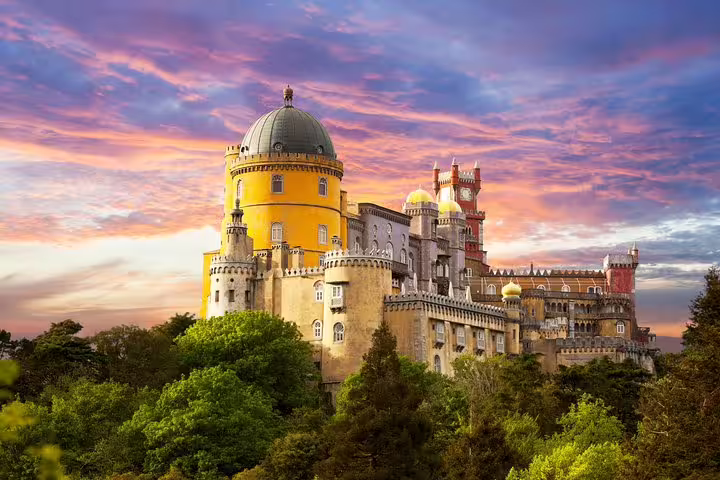 Colorful Pena Palace in Sintra, Portugal, under a vibrant sunset sky, featured in a private tour of Sintra and Lisbon.