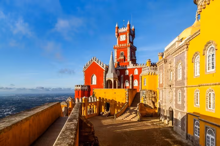 Vibrant Pena Palace in Sintra under a clear blue sky, featured in a private tour from Lisbon.