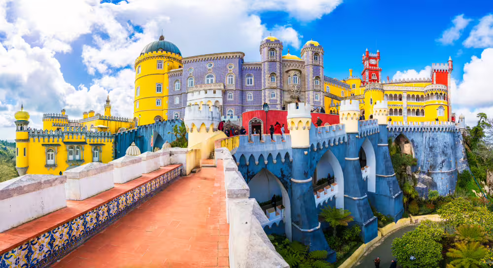 Colorful Pena Palace in Sintra, Portugal, showcasing vibrant architecture on a sunny day, part of the Lisbon tour package.