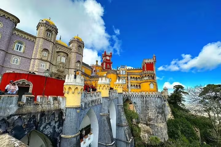 Vivid view of the colorful Pena Palace in Sintra, Portugal, showcasing stunning architecture during a guided mountain tour.
