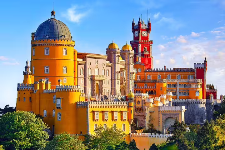 Vibrant view of Pena Palace in Sintra, Portugal, showcasing its colorful architecture and lush surroundings on a sunny day.