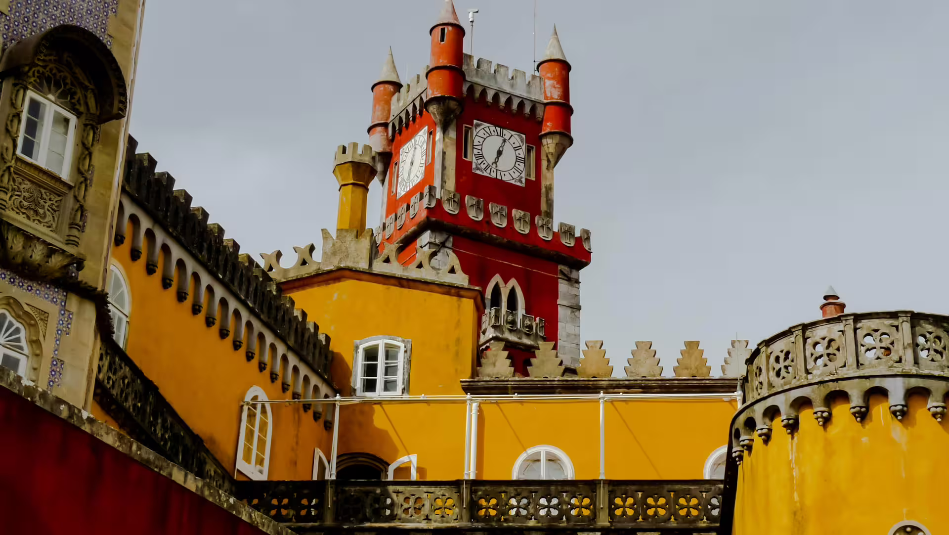 Vibrant yellow and red towers of Pena Palace in Sintra, Portugal, showcasing unique architecture on a scenic tour.