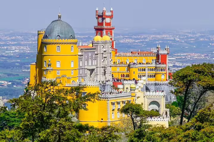 Vibrant view of Pena Palace in Sintra, Portugal, showcasing its colorful architecture on a private tour from Lisbon with monument tickets.