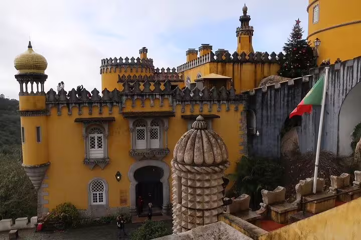 Explore the vibrant architecture of Pena Palace on a private Sintra tour from Lisbon, featuring stunning palatial views.