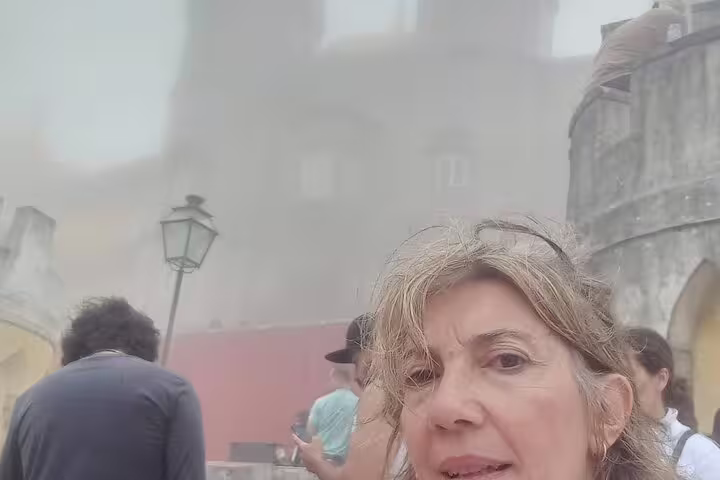 Tourists exploring the misty grounds of Pena Palace during a private Sintra tour from Lisbon or Cascais.
