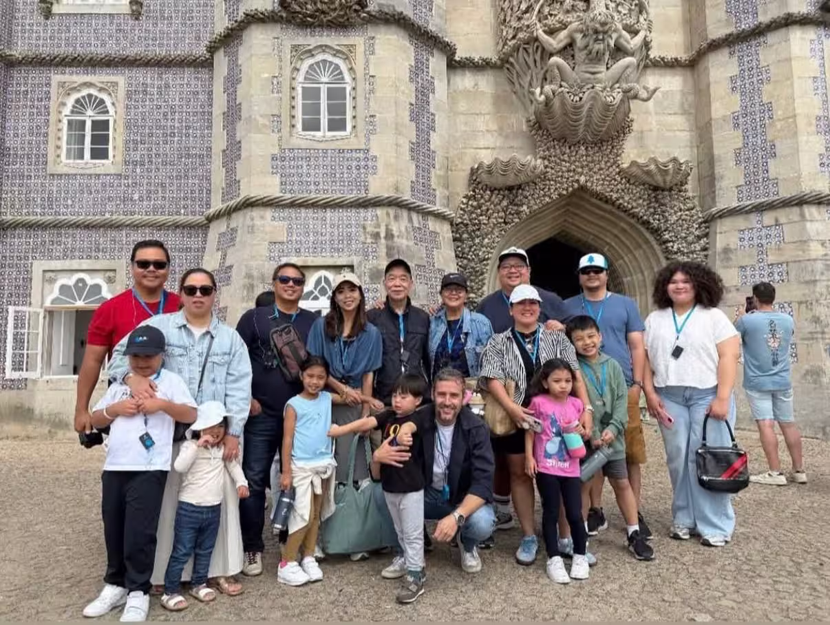Group of tourists enjoying a visit to the historic Pena Palace in Sintra, showcasing its unique architectural details.