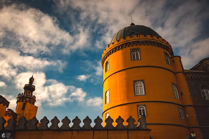Yellow dome tower of Pena Palace in Sintra under dramatic sky, highlight of self-drive monuments tour