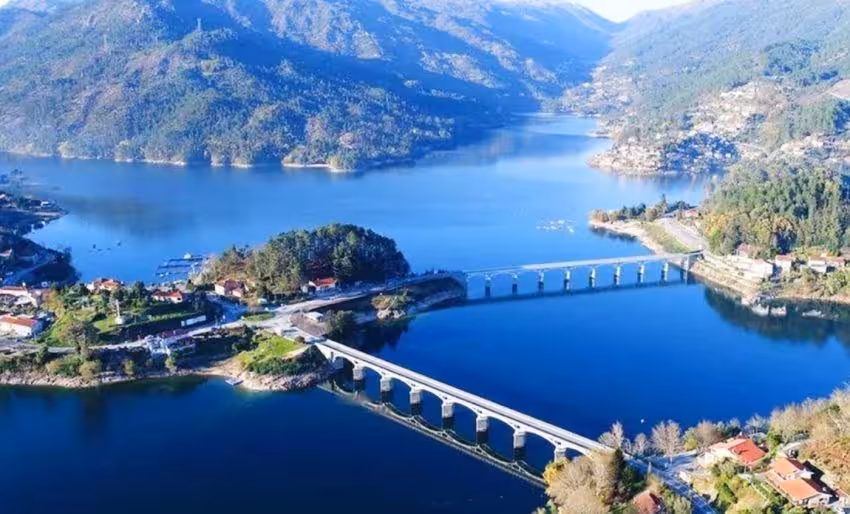 Aerial view of Peneda Geres National Park featuring a scenic lake and mountain landscape with a bridge.