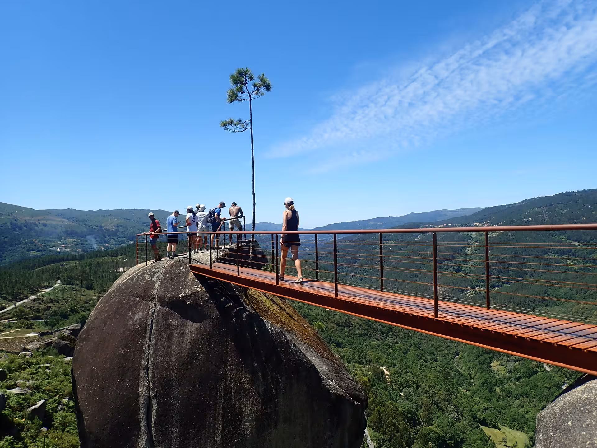 Visitors on a bridge with breathtaking views in Peneda-Gerês National Park during a guided tour.