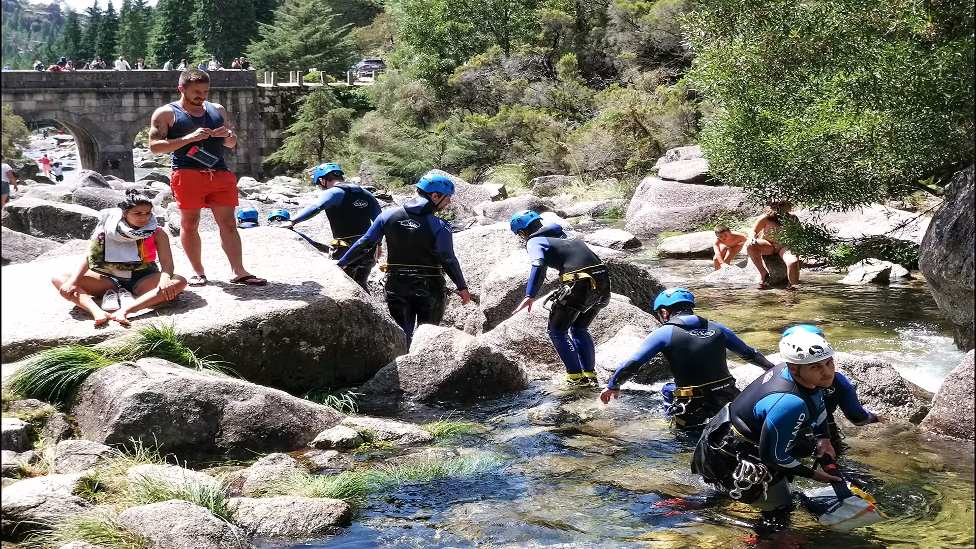 Visitors enjoy canyoning and relaxing by the river in Peneda-Gerês National Park, showcasing adventure and natural beauty.
