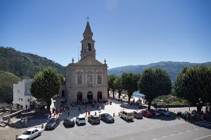 Scenic view of a historic church surrounded by lush hills in Peneda-Gerês National Park, Portugal.