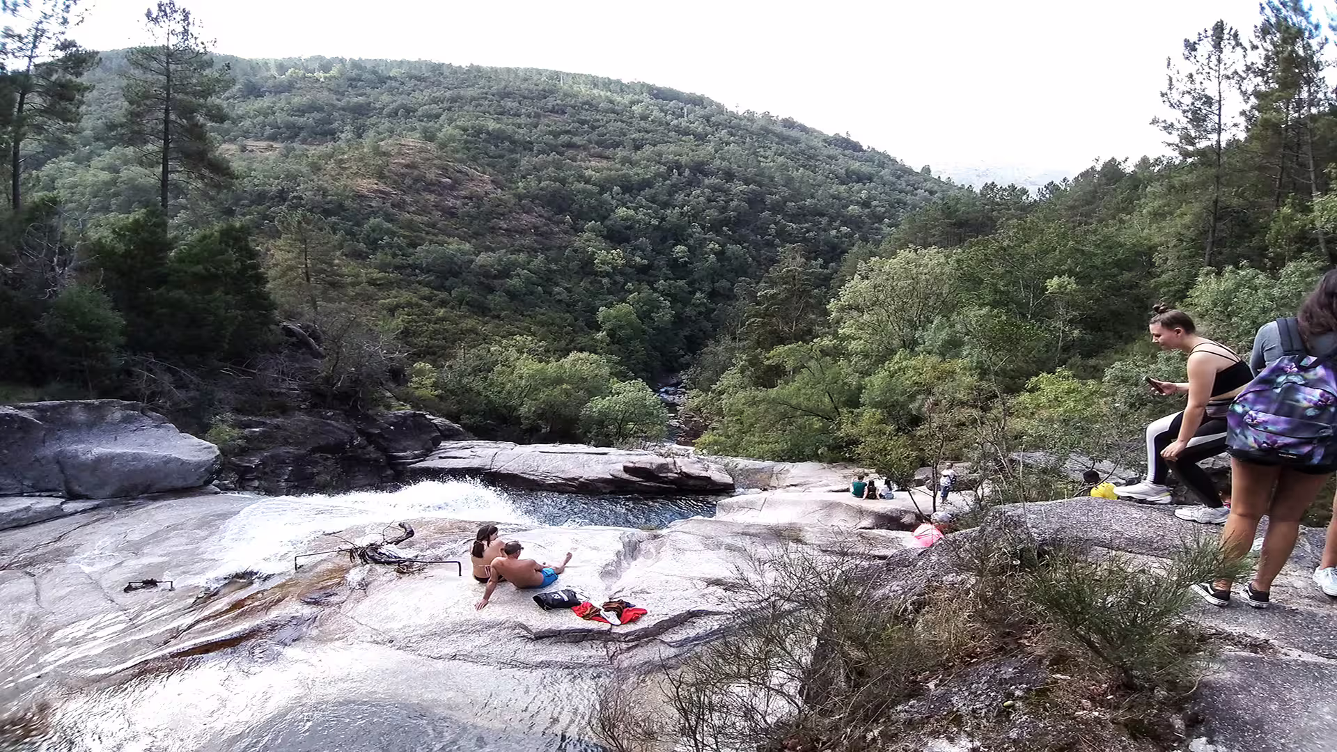 Visitors enjoying the scenic views and natural rock pools at Peneda-Gerês National Park during a private nature tour.