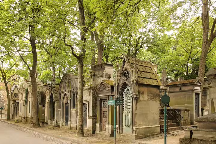 Historic tombs and lush greenery at Père Lachaise Cemetery, a serene stop on the Paris private full day tour of Montmartre and Eiffel Tower.
