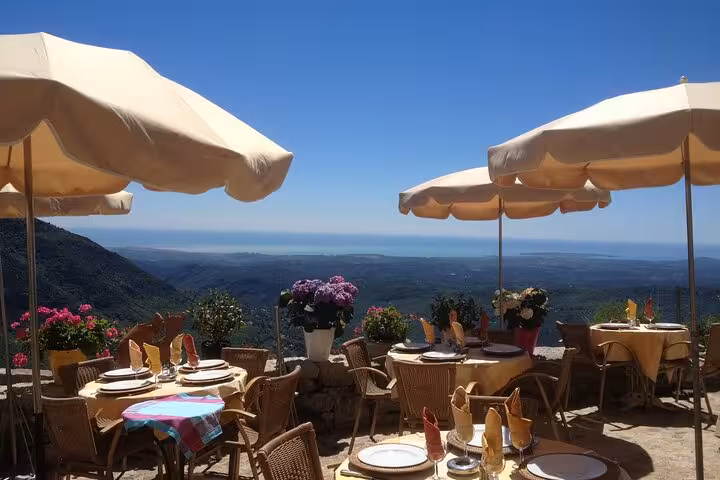 Scenic outdoor dining with panoramic views of rolling hills and coastline on a perfume factory and local villages tour.