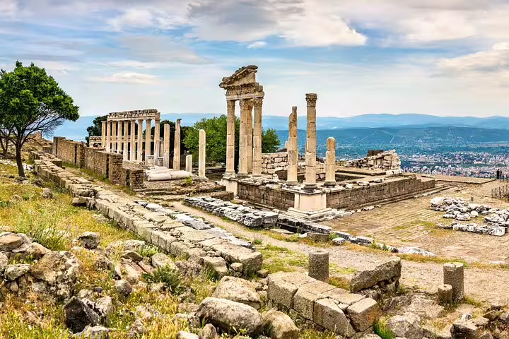 Scenic view of ancient Pergamon ruins with remaining columns and cityscape backdrop on the Kusadasi tour.