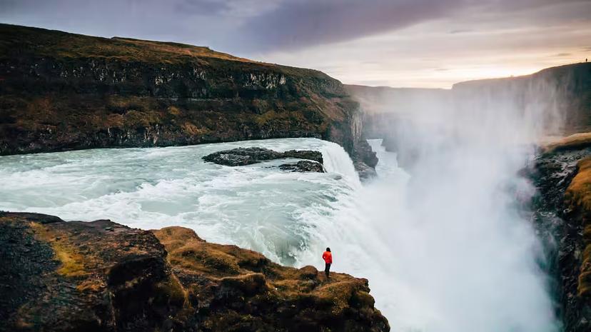 A person standing on close to a gigantic waterfall