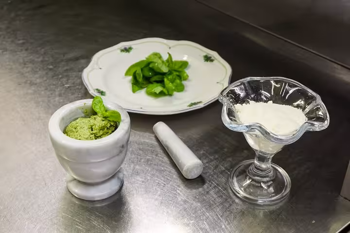 Ingredients for pesto sauce, featuring fresh basil, cheese, and a marble mortar, perfect for a Rome cooking class.