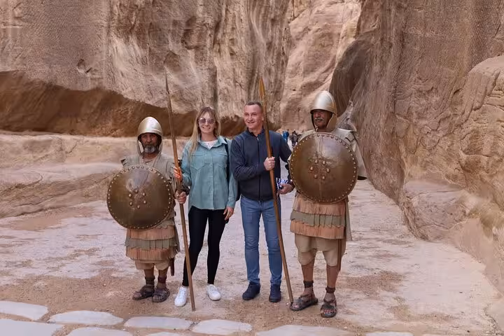 Couple posing in Petra Siq with Bedouin guards in armor, Sharm El Sheikh to Petra day trip by ferry