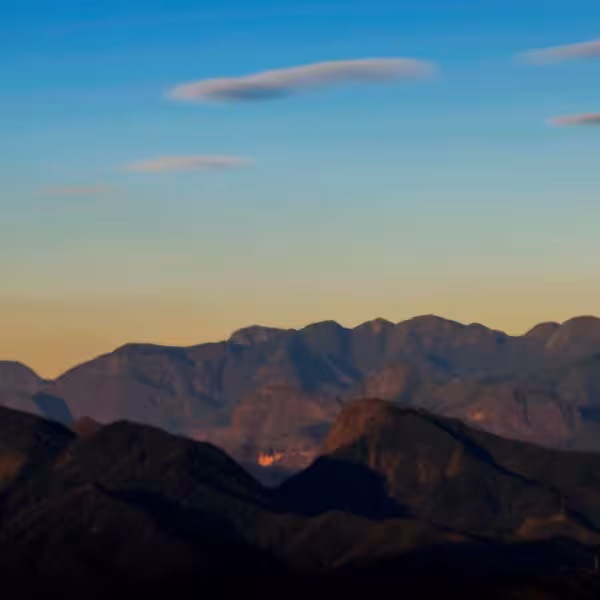 Scenic view of the Serra dos Órgãos mountain range with vibrant sunset hues in Petrópolis, Brazil.