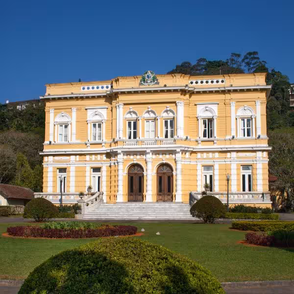 Stunning yellow neoclassical building surrounded by manicured gardens, a must-see on Petrópolis tours.